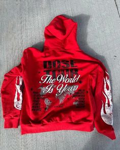 a red hoodie with white writing on the front and back, that says rise to the world in your hands