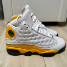 This Pair Of Air Jordan 13 Retro Sneakers In The Del Sol White Gold Colorway Is A Must-Have For Any Sneakerhead. The Shoes Are Gently Preowned And Come In A Size 4 Youth, Equivalent To A Women's Size 5.5 Or A Men's Size 4. The Mid-Top Sneakers Feature A Lace-Up Closure And Standard Width. The Shoes Are Perfect For Activewear Occasions And Have A Multicolor Design. The Air Jordan 13 Retro Sneakers Are Part Of The Iconic Air Jordan Product Line And Bear The Jordan Brand Name. They Were Manufactured In Indonesia And Are Not Signed Or Vintage. These Athletic Shoes Are Not Customized And Are Ready To Wear. Don't Miss Out On The Opportunity To Own A Piece Of Sneaker History. Used But Jordan Shoes For Light Sports With Round Toe, Jordan Shoes With Laces For Light Sports Round Toe, White High-top Running Shoes With Perforations, White Jordan Shoes For Light Sports, White Jordan Shoes With Laces For Light Sports, White Jordan Shoes For Light Sports With Rubber Sole, White Jordan Shoes With Rubber Sole For Light Sports, Jordan Shoes With Perforations And Round Toe, White Mid-top Jordan Running Shoes