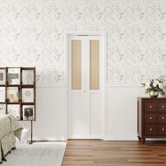 a room with a bed, dresser and wallpapered walls in white color scheme