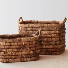 two woven baskets sitting on top of a wooden table