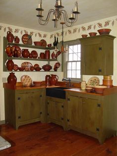 a kitchen filled with lots of brown and white dishes on top of wooden shelves next to a window