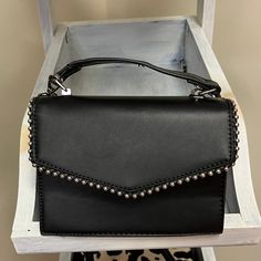 Introducing the Studded Purse, a chic fusion of edgy style and practical sophistication. This black purse is adorned with a bold stud-lined pattern, adding a touch of rock-inspired flair to your ensemble. Crafted with both fashion and functionality in mind, the Studded Purse features a convenient long strap for versatile wear – effortlessly transitioning from a stylish crossbody to an elegant shoulder bag. The sleek black color ensures easy pairing with a range of outfits, while the studs provide a bold statement for those who appreciate a touch of rebellion in their accessories. Black Wallets With Chain Strap For Everyday Use, Chic Shoulder Flap Bag With Gunmetal Hardware, Chic Flap Shoulder Bag With Gunmetal Hardware, Black Wallets With Chain Strap, Trendy Black Shoulder Bag With Gunmetal Hardware, Black Rectangular Wallets With Chain Strap, Black Rectangular Wallet With Chain Strap, Trendy Crossbody Flap Bag With Metal Hardware, Trendy Crossbody Shoulder Bag With Gunmetal Hardware