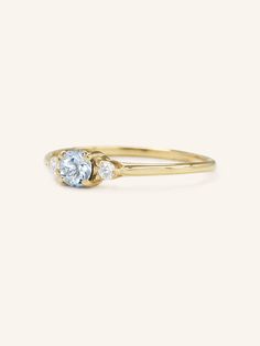 a yellow gold ring with two diamonds on the top and one diamond in the middle