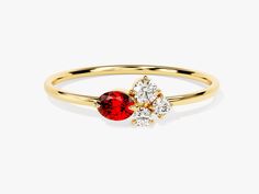 a yellow gold ring with two red and white stones on the side, set against a plain background