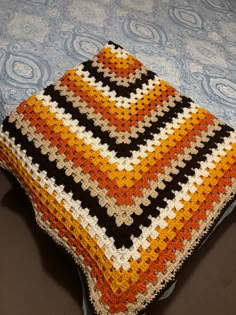 a crocheted blanket sitting on top of a bed