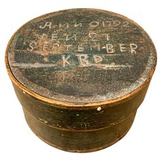 an old round wooden box with writing on the inside and outside, isolated against a white background