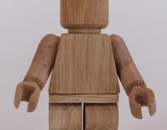 a small wooden toy with one hand on it's head and two fingers in the other