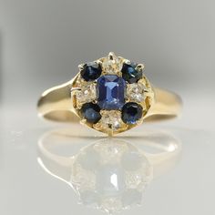 Victorian Sapphire And Diamond Cluster Ring Circa 1900. 18 carat yellow gold with Hallmarks and an indistinct 18 carat stamp. Claw set with a central oval cut mid blue sapphire. Complemented by an outer cluster of four further round blue sapphires and four old cut diamonds. Total diamond content measures approximately .40 carat. Diamonds G Colour, VS/SI Clarity. Sapphires measure approximately .80 carat. Diamonds and sapphires are all claw set. Plain shoulders. Plain band shank. To the reverse the sapphires and diamonds are set in open backed settings, this allows the light to shine through. The head of the ring measures approximately 12 mm across. This would make a wonderful dress or engagement ring. The majority of our rings can be resized. The first resizing will be done at our expense Plain Bands, Diamond Cluster Ring, Diamond Cluster, Sapphire Diamond, Cluster Ring, Blue Sapphire, Colored Diamonds, Ring Verlobung, Diamond Cuts