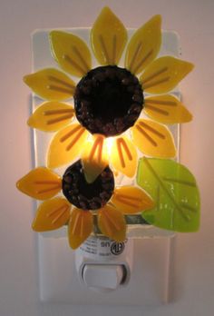 a light that is on the side of a wall with sunflowers in it