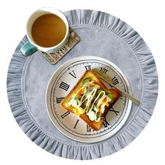 a white plate topped with a piece of toast next to a cup of coffee