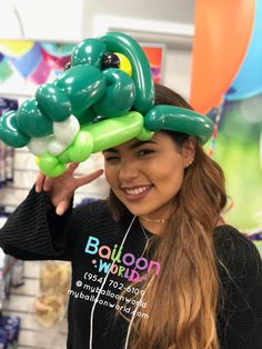 a woman with headphones on holding up an inflatable snake balloon to her face