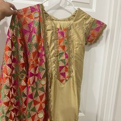 Gold Phulkari Salwar Suit. Dupatta And Embroidered Salwar Included. Brand New, Never Worn. Length 35" Chest 16" Waist 14" Hips 18" Salwar Length 38" Salwar Ankle 7" Bollywood Style Churidar With Multicolor Embroidery And Dabka Work, Bollywood-style Embroidered Churidar With Dabka Work, Multicolor Embroidered Dabka Work Salwar Kameez For Festivals, Multicolor Embroidery Salwar Kameez With Dabka Work For Festivals, Semi-stitched Multicolor Embroidered Churidar For Navratri, Bollywood Designer Churidar With Multicolor Embroidery, Multicolor Embroidered Zari Work Churidar For Festivals, Multicolor Embroidery Churidar With Dupatta And Straight Kurta, Multicolor Embroidered Churidar With Zari Work For Festivals