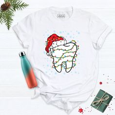 Christmas Teeth Shirt, Christmas Dentist Shirt, Pediatric Dentist Shirt, Christmas Shirt, Dental School Tee, Dentistry Christmas Shirt. Hi! Welcome to our store. It's good to see you here. Our aim is to offer you first-class clothing in your most beautiful moments with our graphic t-shirts that we designed or designed with your ideas. I am sure you will like our designs for your family, friends and you. IMPORTANT MATTERS FOR ORDERING: 1-) Please check and review all photos. 2-) Our sizes are true to size, but can you take a look at my measurements in the product details section to make sure you get the best fit? The measurement is from armpit to armpit. Please let me know if you have any questions. BUSINESS DAYS: Normally postal time is 2-6 working days, rush mail is 1-4 working days, and Dentist Shirt Ideas, Holiday Dental Office Shirts, Dental T Shirts Design, Christmas Dental Shirt, Predental T Shirts, Dental School, Class Outfit, Pediatric Dentist, School Tees