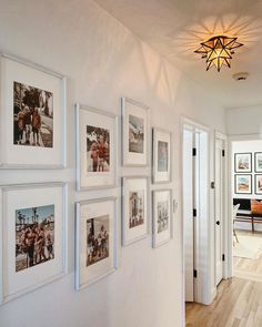 a hallway with white walls and pictures on the wall