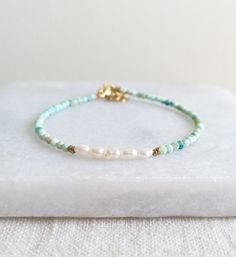 Beautiful Natural Turquoise beads and delicate Freshwater Pearls are used to create this modern boho beaded bracelet. D E T A I L S - Made with high quality Turquoise and Freshwater Pearl beads. - Five delicate Freshwater Pearls are centered among stunning natural Turquoise beads. - Non-tarnish 14k Gold-Filled chain adjuster. Gold-filled is a wonderful alternative to solid gold, and unlike gold plating, it is made to last a lifetime. - Lobster clasp closure. - Comes with a 1 inch adjuster. S I Z