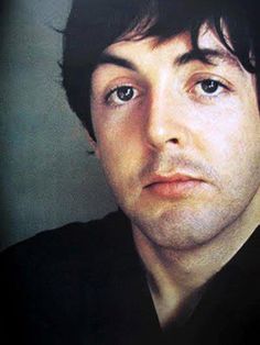 a close up of a person wearing a black shirt and looking at the camera with an intense look on his face