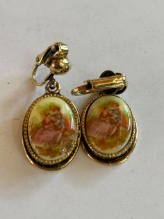 Vintage Goldtoned Clipon Earrings with old Courting Scene measuring 1x3/4" Collectible Victorian Oval Earrings, Antique Clip-on Earrings For Anniversary, Vintage Brass Clip-on Earrings, Victorian Oval Earrings For Collectors, Vintage Dangle Earrings For Anniversary, Antique Round Earrings With Screw Back, Formal Vintage Charm Drop Earrings, Antique Oval Collectible Earrings, Vintage Metal Earrings For Anniversary