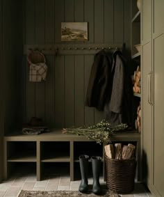 a coat rack and some boots are on the floor next to a bench in a mud room