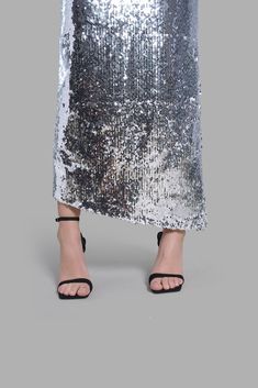 This mid-rise Silver Sequin Diagonal Maxi Skirt has an asymmetrical cut at the bottom. This skirt is noted for its uniqueness in design and its versatility. This product is styled with the Black Satin Arc-Cut Top. Asymmetrical Cut, Cut Top, Cape Coat, Silver Sequin, In Design, Skirt Top, Black Satin, Coat Dress, Skirt Pants