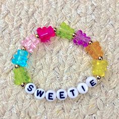 a bracelet with the word sweetie spelled out in white letters and colored gummy bears