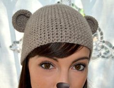 a woman wearing a knitted hat with a fake bear's head on it