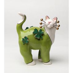 a green ceramic cat with four leaf clovers on its tail