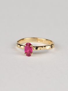 This oval ruby ring is truly exceptional, combining refined design with minimalist charm. It is a timeless piece that is both classically elegant and strikingly modern. The warm tone of the gold beautifully complements the deep red-pink hue of the ruby, creating a stunning contrast that captures attention. The centerpiece of this ring is a gorgeous 0.6-carat ruby sourced from Tanzania. The fluid design of the band reflects light brilliantly, adding a contemporary touch to this exquisite piece. T Timeless Oval Yellow Gold Ruby Ring, Oval Ruby Ring In Yellow Gold Timeless Style, Timeless Oval Ruby Ring In Yellow Gold, Modern Oval Ruby Ring For Wedding, Minimalist Oval Ruby Wedding Ring, Minimalist Oval Ruby Ring For Anniversary, Minimalist Oval Yellow Gold Ruby Ring, Minimalist 14k Gold Oval Ruby Ring, Timeless Oval Ruby Promise Ring