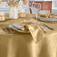 the table is set with silverware and white linens, along with candles and flowers