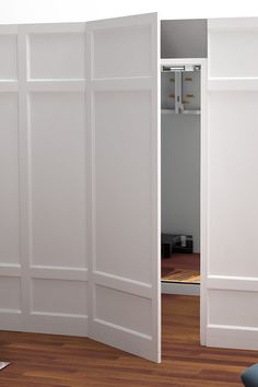 an open closet door in the corner of a room with hard wood floors and white walls