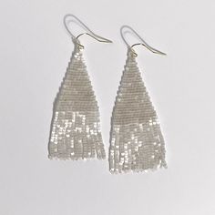 Part of our shine collection. The Wena in all its beauty but smaller. This simple fringe earring is a beautiful crystal white that will simplify any outfit. Hand sewn by amazing women thriving because they have good employment in the Philippines. Materials: glass beads, 14K gold plated hook Measurements: 1" W x 2 1/2"L including hook Fringe Earring, Crystal White, Fringe Earrings, White Silk, The Philippines, Hand Sewn, Amazing Women, Hand Sewing, Philippines