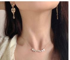 Woman wearing a dainty baroque pearl necklace, complementing her elegant attire. Pearl Necklace Real, Delicate Gold Chain, Real Pearl Necklace, Understated Luxury, Baroque Pearl Necklace, Freshwater Pearl Necklace, Gold Threads, Freshwater Pearl Necklaces, Simple Earrings