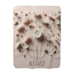 a pink blanket with white daisies on it and the words, blessed written in black