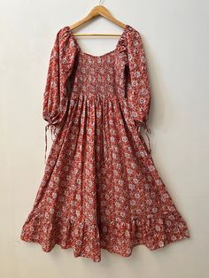 "Women's cotton dress, bohemian smocked long dress, Indian cotton maxi, hand block print cotton gown, ruffle sleeves floral long dress, hippie dresses, cotton maxi, long maxi, comfortable dress, smocking maxi dress, ruffle dresses, summer dresses, floral dress, boho dresses, vintage gown Feel beautiful and confident throughout your days wearing our block printed outfits, made with high quality soft and breathable cotton fabric.  The print on the dress is known as \"BLOCK PRINT\" which is centuries old technique of Indian textile carried out  by local artisans of Jaipur (INDIA) MEASUREMENTS (in inches): Size XXS-: Bust- 34″ | Shoulder- 13.5″ | Length- 51″ Size XS-: Bust- 36″ | Shoulder- 14″ | Length- 51″ Size S-: Bust- 38″ | Shoulder- 14.5″ | Length- 51″ Size M-: Bust- 40″ | Shoulder- 15″ | Bohemian Flowy Smock Maxi Dress, Bohemian Flowy Maxi Dress With Smocked Cuffs, Flowy Bohemian Maxi Dress With Smocked Cuffs, Cotton Maxi Smocked Dress With Ruffles, Bohemian Maxi Smocked Dress With Smocked Back, Bohemian Cotton Smocked Dress With Smocked Cuffs, Cotton Maxi Smocked Dress, Bohemian Cotton Dress With Smocked Back, Bohemian Flowy Smocked Dress With Floral Print