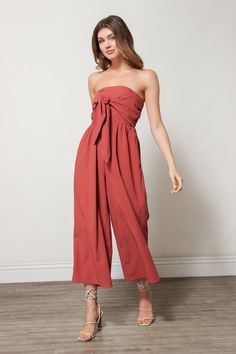 We're feeling sophisticated and sleek in this strapless jumpsuit. The Charlie Jumpsuit in Cinnamon is perfect for any and every upcoming event you may have. Pair this piece with strappy heels and a small handbag to complete the look.  Composition & Fit Strapless Tie Front Detail Gathered Waistline Pleated Leg Hem Rust Jumpsuit, Fashion Model Drawing, Flowy Jumpsuit, Only Jeans, Cropped Jumpsuit, Strapless Jumpsuit, Small Handbag, School Fashion, Strappy Heels