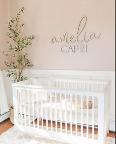 a white crib in front of a pink wall with the name melia capri on it