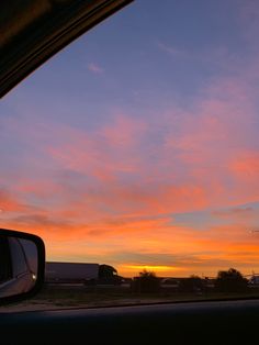 the sun is setting in the distance as seen from inside a car