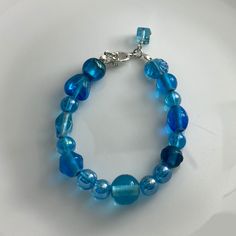 Discover the beauty of our Crystal Blue Lamp Work Glass Bead Bracelet, a mesmerizing piece of handcrafted jewelry that adds a touch of elegance to any ensemble. Each glass bead is skillfully crafted with intricate details, showcasing the captivating shades of crystal blue that catch the light beautifully. 🌟 Handcrafted Elegance 🌟 Indulge in the artistry of this lamp work glass bead bracelet, lovingly handcrafted to create a one-of-a-kind accessory. The combination of exquisite craftsmanship and alluring crystal blue hues makes this bracelet a true statement piece.🛍️ Product Details 🛍️ Material: Lamp Work Glass Beads Bead Color: Crystal Blue Bracelet Length: Adjustable to fit most wrists Clasp: Secure Toogle Clasp Crystal Blue Bracelet, Lamp Work Glass Bead Jewelry, Handcrafted Accessor Dainty Accessories, Glass Bead Jewelry, Blue Lamp, Glass Bead Bracelet, Glass Beads Jewelry, Handcrafted Accessories, Delray Beach, Crystal Blue, Jewelry Beaded