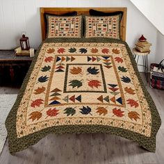 a bed covered in a quilt with leaves on it