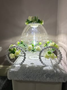 a white table topped with a glass vase filled with flowers