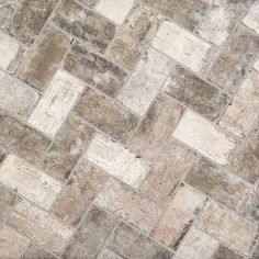 a close up view of a stone floor with white and brown tiles on it's sides