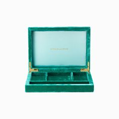 an open green velvet jewelry box on a white background