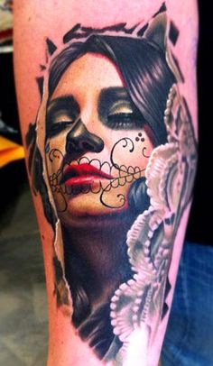 a woman's arm with a skull and flower tattoo on her left arm,