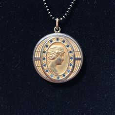 "This elegant Art Deco gold filled locket features a finely sculpted profile of a lovely lady surrounded by an oval ring of dark glittering paste stones and another ring of interesting engravings. The back of the locket has the initials \"RB\" engraved in Edwardian-style lettering. Inside, you can see the letters \"C, Q, and R\" in a small triangle which indicates the jewelry company who crafted this locket was the esteemed Carter, Qvarnstrom, & Remington of Attleboro, MA (they produced lock 1920s Necklace, Vintage Lockets, Elegant Art, Oval Rings, Edwardian Fashion, Jewelry Companies, Locket Necklace, Ball Chain, Fire Opal