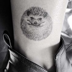 a small hedgehog tattoo on the right ankle and leg, with an animal's face