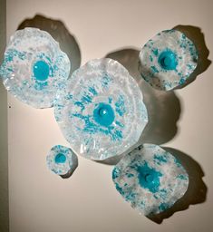 three blue and white soaps sitting on top of each other in front of a wall