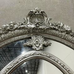 an ornate silver mirror is on display in a store