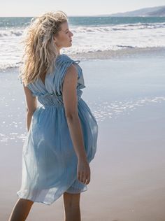 Ethereal and the color of blue skies and lapping waves. Our Goddess dress is light and airy with drawstring shoulder and ruched elastic empire waist detailing. 100% cotton deadstock cotton voile One Size S/M Chest width flat 18" Empire elastic waist flat 13", stretches to 19" Hip width flat 24" Body length from shoulder 42" Fully lined Hand wash cold, line dry, or dry clean Consciously made in small batches in sunny California using deadstock fabrics and recycled materials. Seasonless essentials Blue Flowy Empire Waist Maxi Dress, Flowy Cotton V-neck Beach Dress, V-neck Cotton Gauze Beach Dress, Feminine V-neck Beach Nightgown, Bohemian Light Blue V-neck Mini Dress, Sunny California, Goddess Dress, Cotton Voile, Empire Waist