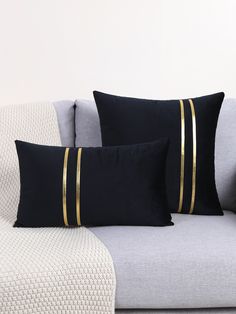 three black and gold pillows on a couch