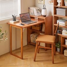 a laptop computer sitting on top of a wooden desk next to a book shelf filled with books