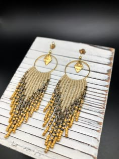 ⋄ Handwoven seed bead fringe earrings made with high quality Japanese Miyuki Delica glass beads ⋄ 100% brass hoop ⋄ gold plated ear wire (nickel free & hypoallergenic)         ⋄ PLEASE DIRECT MESSAGE me with any questions regarding ear wire material, other options ARE available upon request :)  ⋄ Handmade to order ** Please message me if you have any questions or would like to make changes to the original design! I am happy to do what I can :) drop length: 2.75" full length with ear wire: 3.25" Beaded Brass Earrings For Festival, Bohemian Brass Beaded Earrings With Tiny Beads, Beaded Dangle Earrings In Brass, Brass Beaded Earrings With Round Beads For Festival, Gold Artisan Beaded Fringe Earrings, Festival Brass Beaded Earrings With Gold Beads, Gold Beaded Brass Earrings For Festivals, Bohemian Heishi Beads Dangle Jewelry, Gold Heishi Beads Earrings